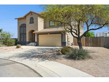 Two-story stucco home featuring a two-car garage, landscaped front yard, and desert-friendly landscaping at 44390 W Buckhorn Trl, Maricopa, AZ 85138