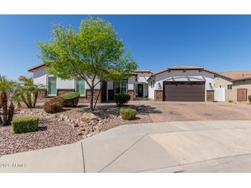 Charming single-story home boasts stucco exterior, landscaped front yard with mature tree and brick paver driveway at 5114 S Leisure Ct, Gilbert, AZ 85298