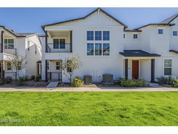 Inviting exterior view of a bright, modern townhome with a small porch and well-maintained landscaping at 11300 N Casa Dega N Dr # 1047, Surprise, AZ 85388