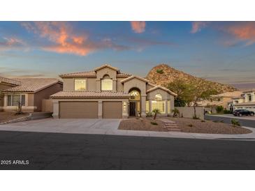 Inviting two-story home boasts desert landscaping, a three-car garage and mountain views at 14823 S 13Th Pl, Phoenix, AZ 85048