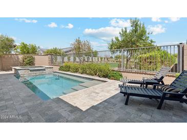 Backyard pool featuring a built-in spa and ample patio space perfect for relaxing or entertaining at 17332 W Wildwood St, Surprise, AZ 85388