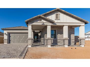 Charming home with a brick facade, covered porch, and well-manicured landscaping at 2606 E Virginia Cir, Mesa, AZ 85213