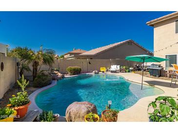 Inviting backyard with a private pool, lush landscaping, and ample patio space at 26066 N 72Nd Ave, Peoria, AZ 85383