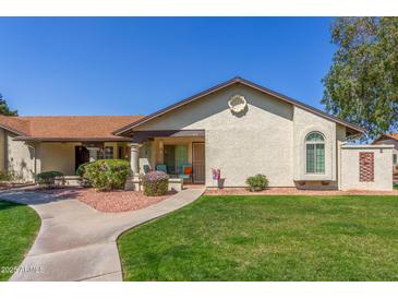 Charming home featuring a well-maintained lawn, lovely desert landscaping, and a welcoming front porch at 8140 N 107Th Ave # 120, Peoria, AZ 85345