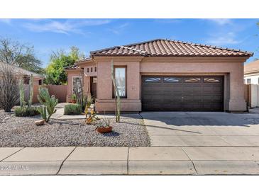 Attractive home with desert landscaping, a two-car garage, and a well-maintained lawn at 903 W Raven Dr, Chandler, AZ 85286