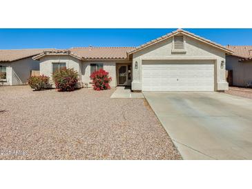 Charming single-story home featuring a two-car garage and low maintenance desert landscaping at 16034 W Carmen Dr, Surprise, AZ 85374