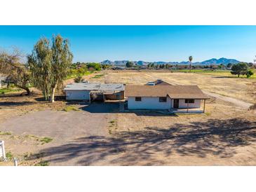Expansive property featuring a charming home and spacious land with mountain views against a clear blue sky at 20521 E Germann Rd, Queen Creek, AZ 85142