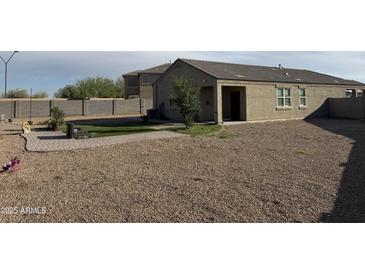 Extensive gravel backyard with desert landscaping, a charming pergola, and a green grass area, creating an inviting outdoor oasis at 29908 W Monterey Dr, Buckeye, AZ 85396