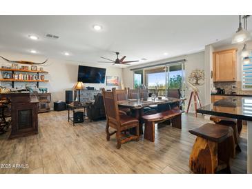 Bright, open-concept living space with stylish wood-look tile flooring and a modern kitchen viewable in the background at 5100 E Rancho Paloma E Dr # 1046, Cave Creek, AZ 85331