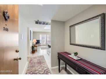 Inviting condo hallway with neutral tones and stylish accents lead into a naturally lit living space at 7960 E Camelback Rd # 209, Scottsdale, AZ 85251