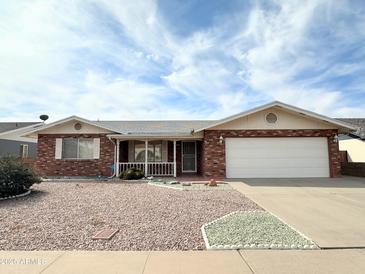 Charming brick home featuring a two-car garage and well-kept landscaping, perfect for suburban living at 8217 E Medina Ave, Mesa, AZ 85209