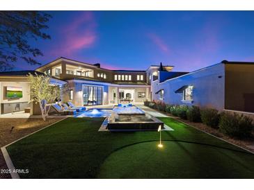 A lush backyard has a putting green, a hot tub, and a pool with lounge seating at 9735 E Kemper Way, Scottsdale, AZ 85255