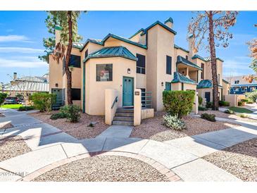 Charming stucco townhome with a quaint front entrance, complemented by desert landscaping and mature trees at 101 N 7Th St # 210, Phoenix, AZ 85034