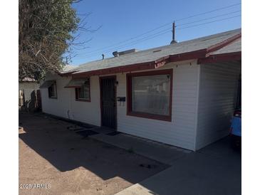 Charming single-story home with white siding, red trim, and a well-maintained front yard at 2937 W Bethany Home Rd, Phoenix, AZ 85017