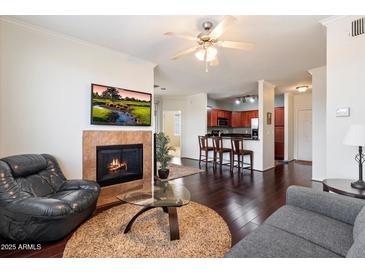 Inviting living room featuring a fireplace, dark wood floors, and a ceiling fan, perfect for relaxing and entertaining at 7009 E Acoma, Lot #2060 Dr # 2060, Scottsdale, AZ 85254