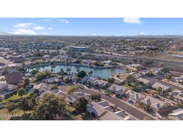 Beautiful aerial view of a lakeside community showcasing well-maintained homes, lush landscaping and blue skies at 19934 N 77Th Ave, Glendale, AZ 85308