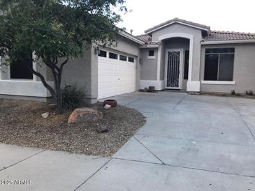 Charming single-story home with a two-car garage and a well-maintained front yard at 2638 W Sat Nam Way, Phoenix, AZ 85086