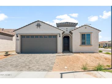 Charming single-story home featuring a gray two-car garage door, neutral paint, and desert landscaping at 26995 W Adam Ave, Buckeye, AZ 85396
