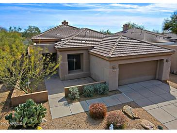 Charming single-story home with desert landscaping, tile roof, and attached two-car garage at 6827 E Eagle Feather Rd, Scottsdale, AZ 85266