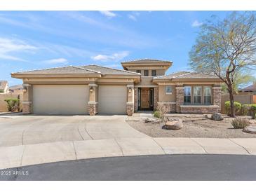 Charming single-story home featuring a three-car garage, stone accents, and desert landscaping at 12493 S 179Th Ln, Goodyear, AZ 85338