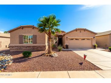 Charming home featuring stone accents, a desert landscape, and a well-manicured lawn at 17613 W Gelding Dr, Surprise, AZ 85388