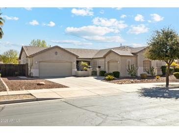 Attractive single-story home featuring a well-kept yard, desert landscaping, and a two-car garage at 19305 E Oriole Way, Queen Creek, AZ 85142