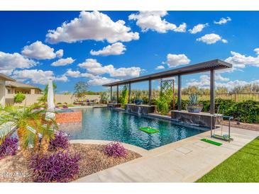 Resort-style pool and spa featuring a pergola, lush landscaping and putting green creates a backyard oasis at 22867 E Via Las Brisas --, Queen Creek, AZ 85142