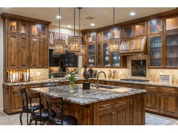 Spacious kitchen featuring custom wood cabinetry, granite countertops, and pendant lighting at 6888 E Mighty Saguaro Way, Scottsdale, AZ 85266