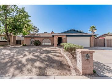 Charming single-story brick home with a two-car garage and a well-manicured front yard at 7416 S Mcallister Ave, Tempe, AZ 85283