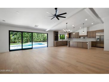 Bright, open-concept living space with kitchen, and access to the pool through sliding doors at 7528 E Windrose Dr, Scottsdale, AZ 85260