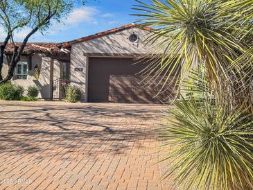 Beige stucco home featuring a clay tile roof, two-car garage, and a paver driveway and walkway at 8964 E Mountain Spring Rd, Scottsdale, AZ 85255