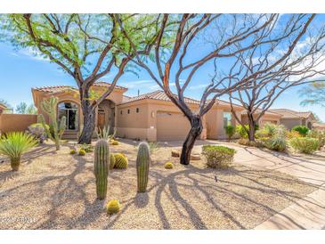 Charming home featuring desert landscaping, a tile roof, and mature trees providing ample shade at 9327 E Whitewing Dr, Scottsdale, AZ 85262