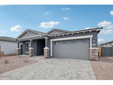 Charming single-Gathering home showcasing a gray exterior, brick accents, and a paved driveway at 11432 E Utopia Ave, Mesa, AZ 85212