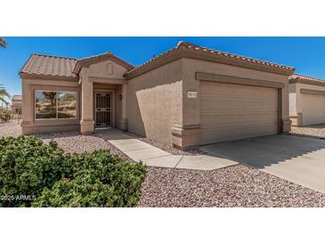 Tan home featuring desert landscaping and a two-car garage at 16115 W Acacia Ct, Surprise, AZ 85374