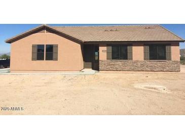 Charming single-story home featuring neutral siding, shuttered windows, and a desert landscape at 22113 W Laura St, Wittmann, AZ 85361