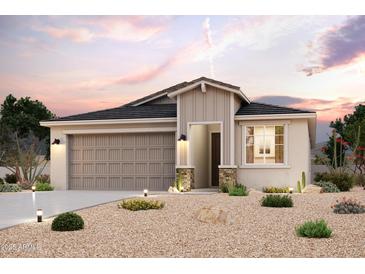 Charming single-story home featuring desert landscaping, a gray garage door, and stylish architectural details at 2486 E Music Mountain Ave, Apache Junction, AZ 85119
