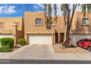 Inviting townhome with two-car garage and charming desert landscaping for a welcoming curb appeal at 2912 E Eberle Ln, Phoenix, AZ 85032
