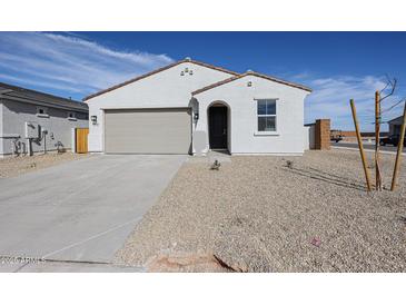 Charming single-story home featuring a neutral color palette, desert landscaping, and a quaint, covered front entrance at 39970 W Bravo Dr, Maricopa, AZ 85138