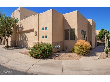 Beige modern home with a two-car garage, desert landscaping, and turquoise trimmed windows at 9070 E Gary Rd # 136, Scottsdale, AZ 85260