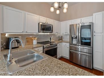 Bright kitchen featuring stainless steel appliances, granite countertops, white cabinets, and a modern chandelier at 927 W Wendy Way, Gilbert, AZ 85233