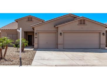 Charming single-story home featuring a two-car garage, desert landscaping, and a well-maintained front yard at 12941 W Flower St, Avondale, AZ 85392
