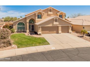 Two-story home with manicured front yard, arched windows and three car garage at 15055 S 40Th Pl, Phoenix, AZ 85044