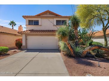 Charming two-story home featuring a two-car garage and vibrant desert landscaping in the front yard at 1683 W Maplewood St, Chandler, AZ 85286
