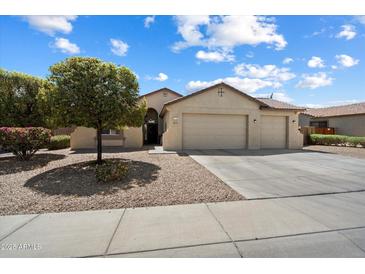 Charming home featuring a three-car garage, lush landscaping, and neutral color palette at 18237 W Port Au Prince Ln, Surprise, AZ 85388