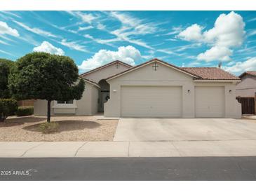 Charming single-story home featuring a two-car garage, desert landscaping, and well-maintained front yard at 18237 W Port Au Prince Ln, Surprise, AZ 85388