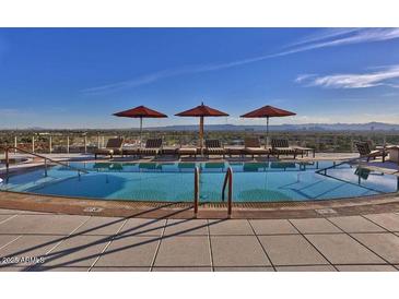 Rooftop pool featuring lounge chairs, sun umbrellas, and scenic views of the surrounding cityscape at 2211 E Camelback Rd # 604, Phoenix, AZ 85016