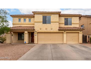 Inviting two-story home with a spacious three-car garage and well-maintained desert landscaping at 43724 W Cowpath Rd, Maricopa, AZ 85138