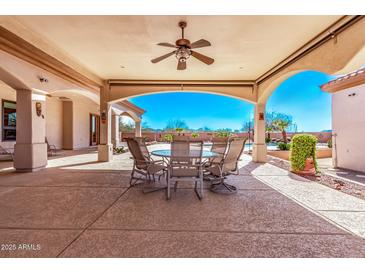 Outdoor patio boasting a dining area, overhead fan, and a picturesque view of the pool at 11440 S 194Th Dr, Buckeye, AZ 85326