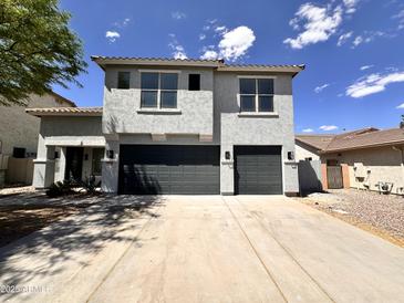 Two-story home featuring a double garage, gray stucco, and concrete driveway under a clear blue sky at 2972 W South Butte Rd, San Tan Valley, AZ 85144