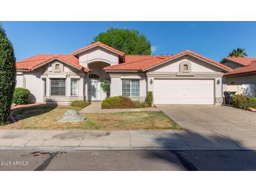Charming single-story home with a red tile roof, well-kept lawn, and a two-car garage at 3109 N Meadow Dr, Avondale, AZ 85392